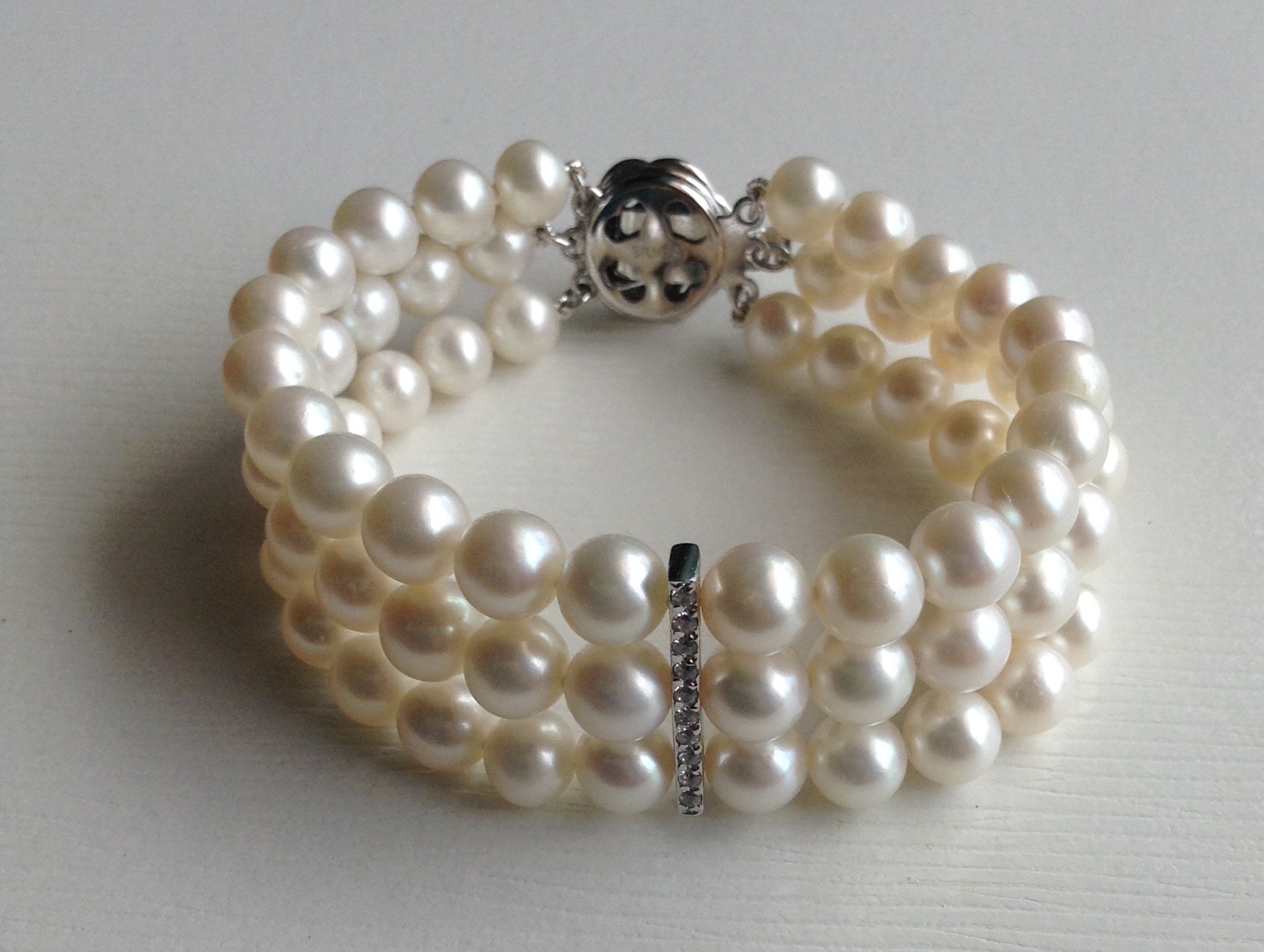 สร้อยข้อมือไข่มุกแท้ สีขาว แบบ 3 ชั้น 5-6 มิล คั่นด้วยข้อเพชรตรงกลาง