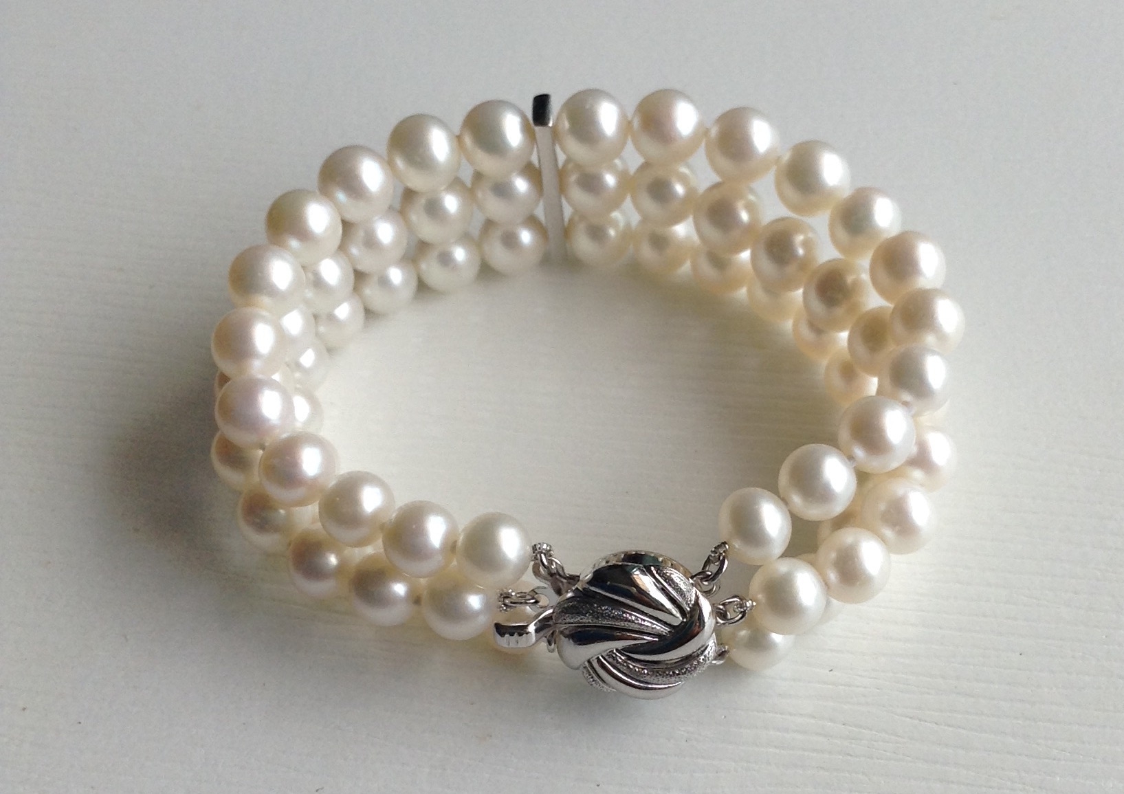 สร้อยข้อมือไข่มุกแท้ สีขาว แบบ 3 ชั้น 5-6 มิล คั่นด้วยข้อเพชรตรงกลาง